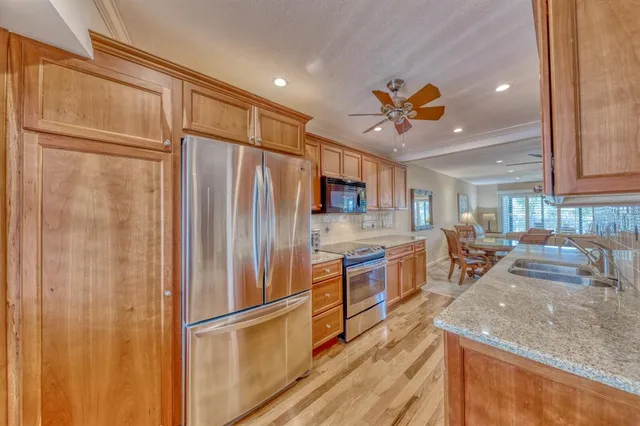a kitchen with stainless steel appliances granite countertop a refrigerator and a sink