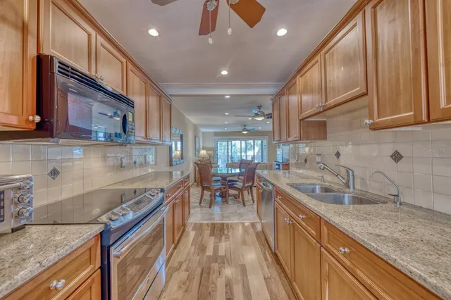 a kitchen with granite countertop sink stainless steel appliances and cabinets