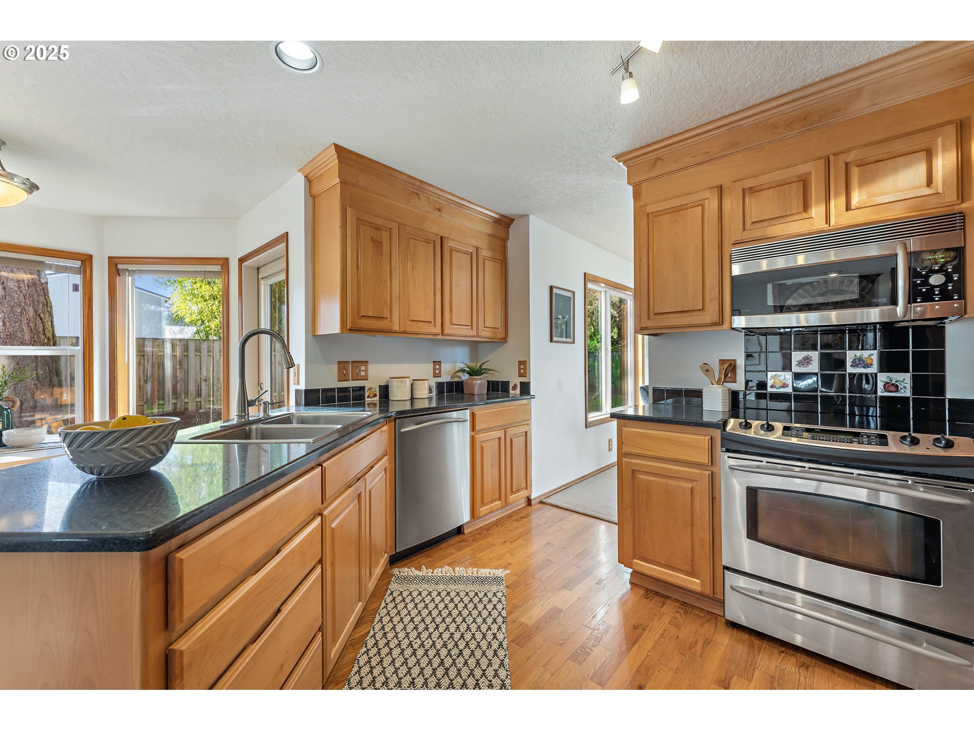 20259 Southwest Celebrity Street Beaverton, OR 97078 - Photo 10 of 40 a kitchen with stainless steel appliances granite countertop a stove a sink and a microwave