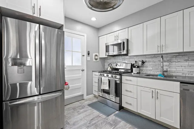 a kitchen with stainless steel appliances granite countertop a refrigerator sink and cabinets
