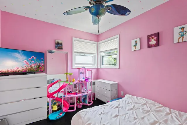 a bedroom with pink walls a pink bed and a window