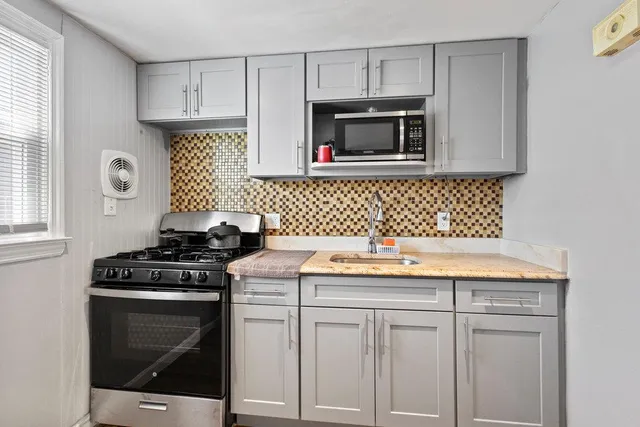 a kitchen with white cabinets and appliances