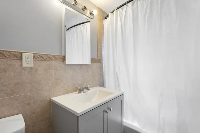 a bathroom with a sink a toilet and a mirror