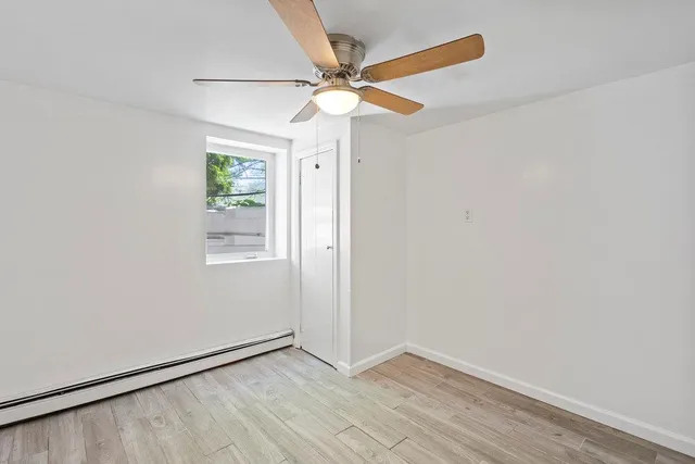 an empty room with windows and fan