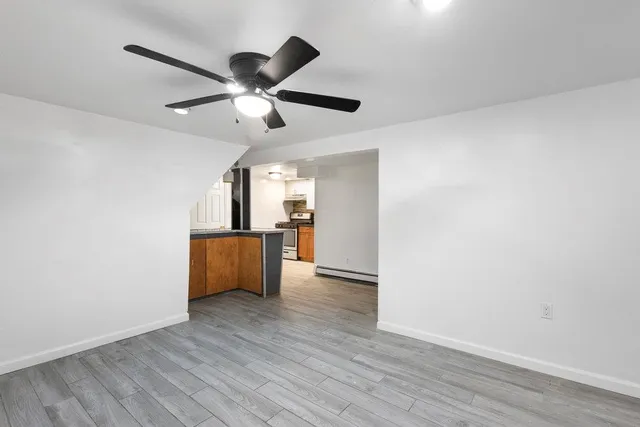 a view of a kitchen with wooden floor and a ceiling fan