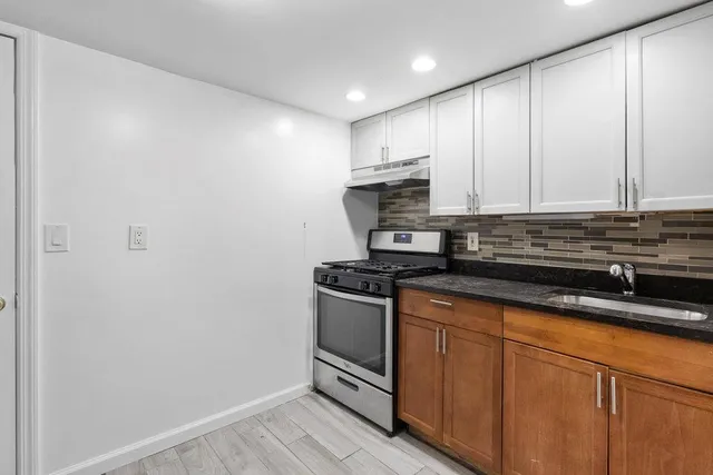 a kitchen with stainless steel appliances granite countertop a sink a stove a microwave and cabinets