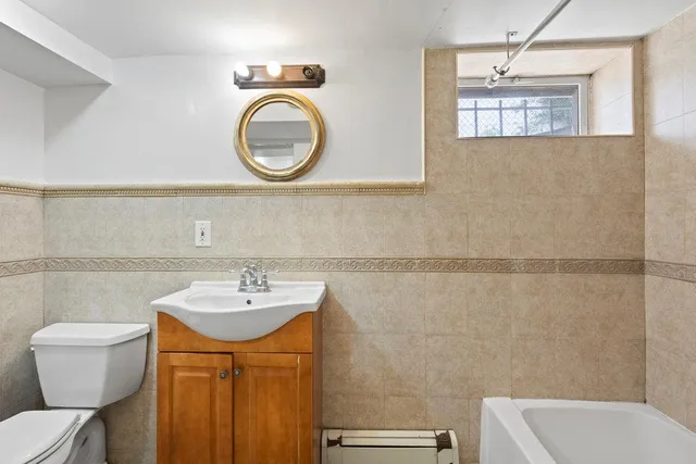 a bathroom with a sink a toilet and a mirror