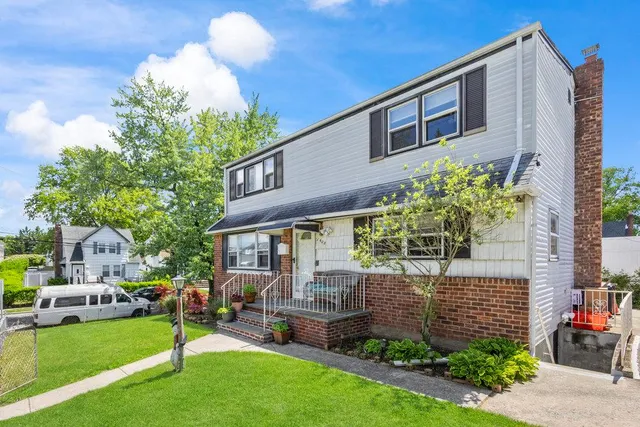 a front view of a house with a garden and plants
