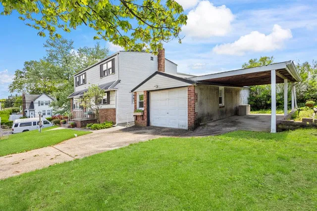 a front view of a house with a garden and yard