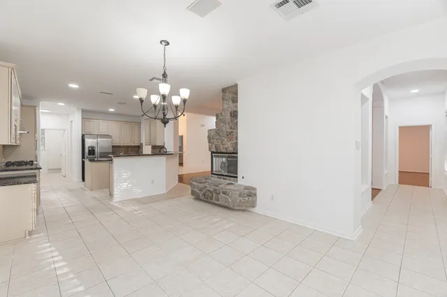 a view of a kitchen with granite countertop a white cabinets and a chandelier