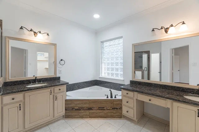 a bathroom with a granite countertop bathtub sink and mirror