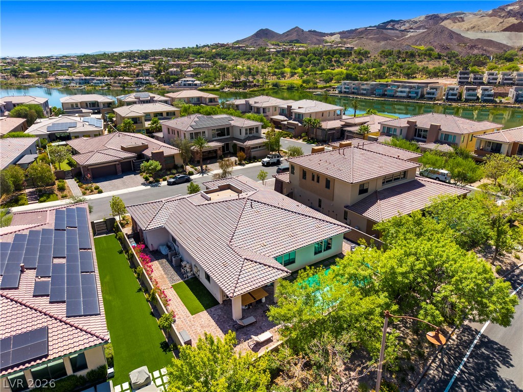 45 Garibaldi Way Henderson, NV 89011 - Photo 45 of 74 An aerial perspective reveals a vibrant community nestled by a serene lake, framed by distant mountains.