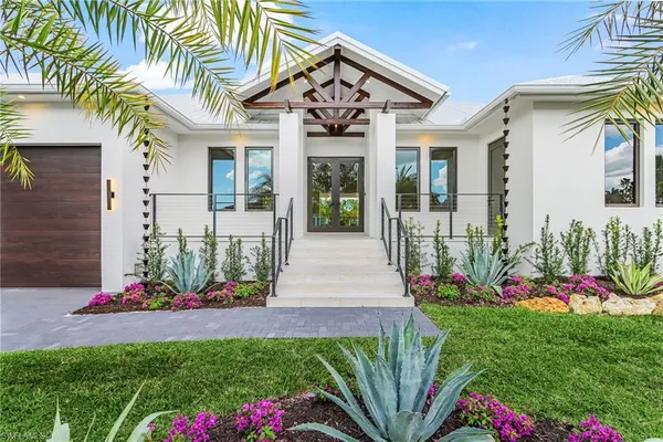 a front view of a house with a yard and fountain