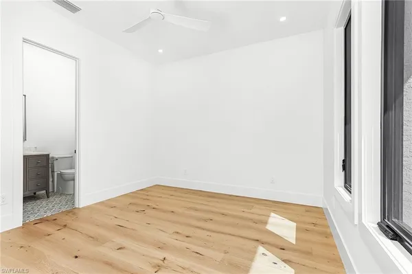 a view of a room with a bed and wooden floor