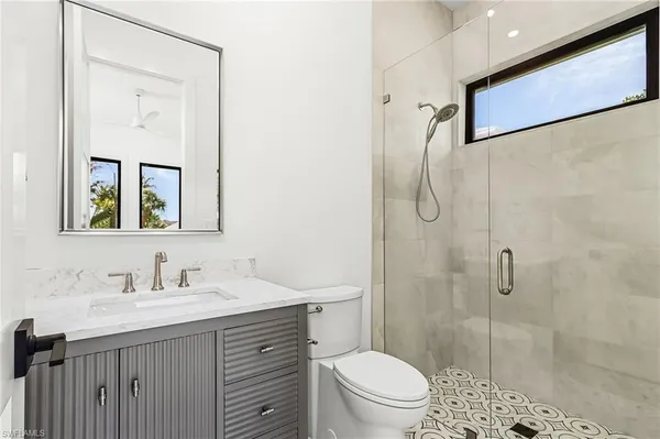 a bathroom with a sink a toilet and shower
