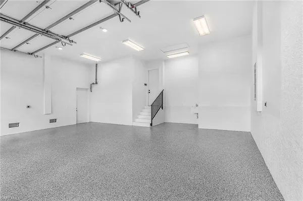 an empty room with a ceiling fan and windows