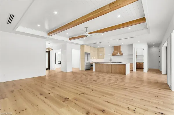 a view of a kitchen with kitchen island a sink wooden floor and a fireplace