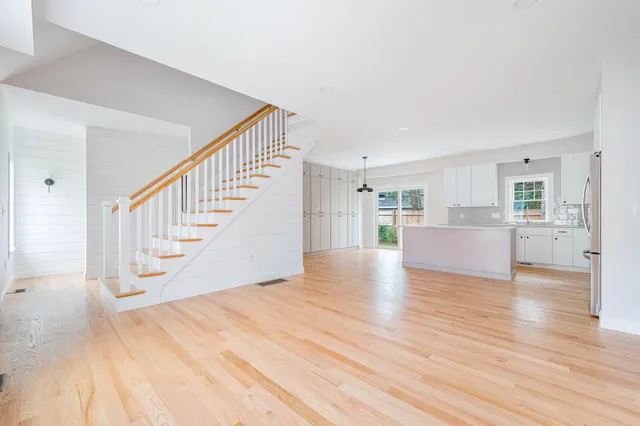 a view of a livingroom with wooden floor and staircase