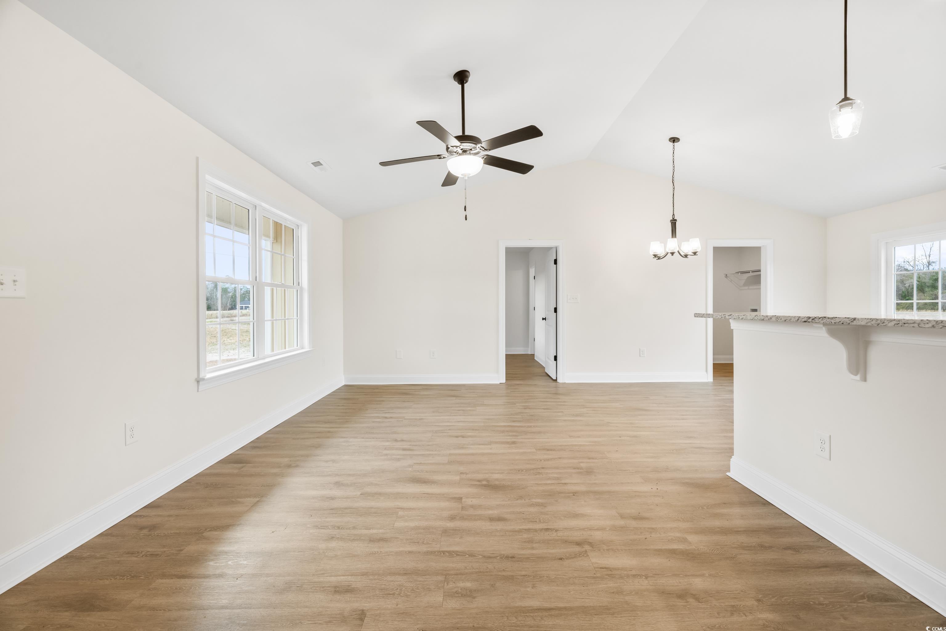 3640 Bethel Chapel Road Loris, SC 29569 - Photo 13 of 35 Unfurnished living room featuring light wood-style flooring, a chandelier, lofted ceiling, ceiling fan, and plenty of natural light