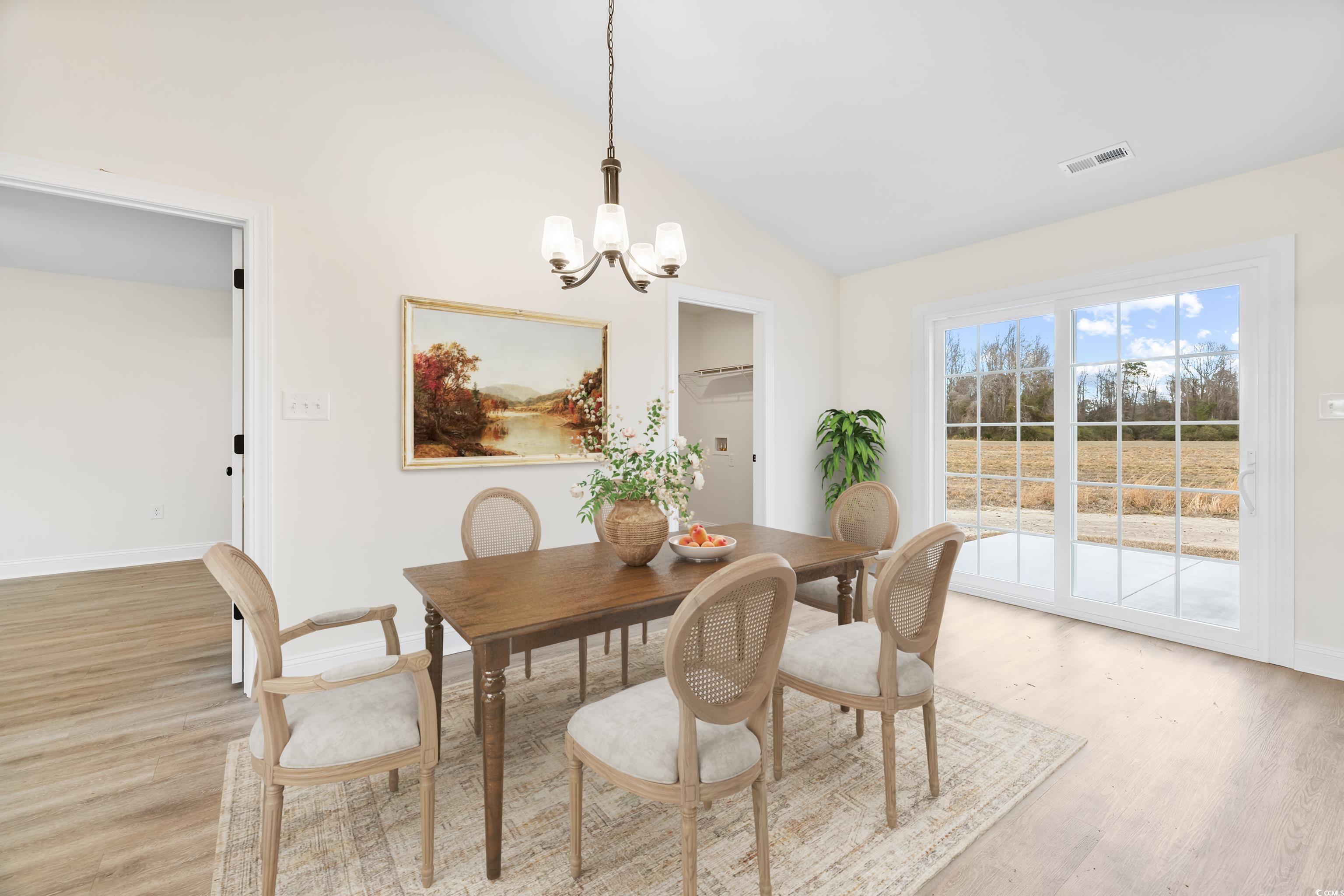 3640 Bethel Chapel Road Loris, SC 29569 - Photo 15 of 35 Dining room with vaulted ceiling, a chandelier, and light wood-style floors
