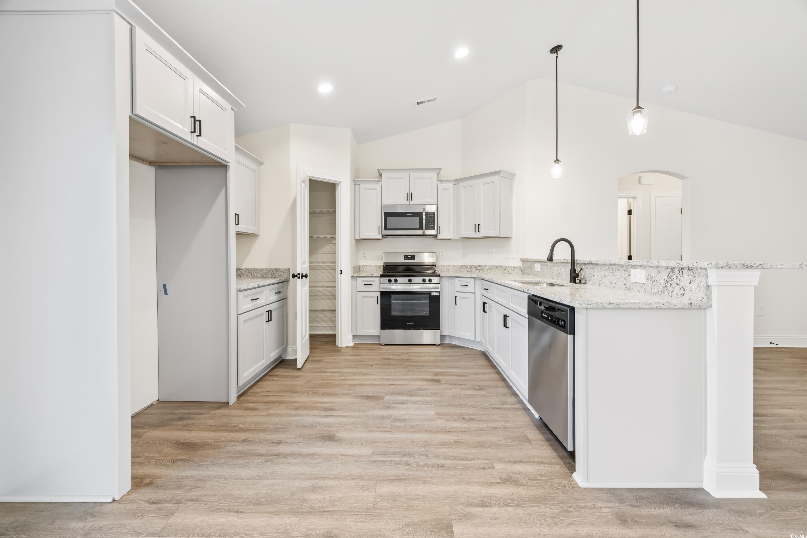 3640 Bethel Chapel Road Loris, SC 29569 - Photo 19 of 35 Kitchen with arched walkways, stainless steel appliances, vaulted ceiling, decorative light fixtures, and a peninsula