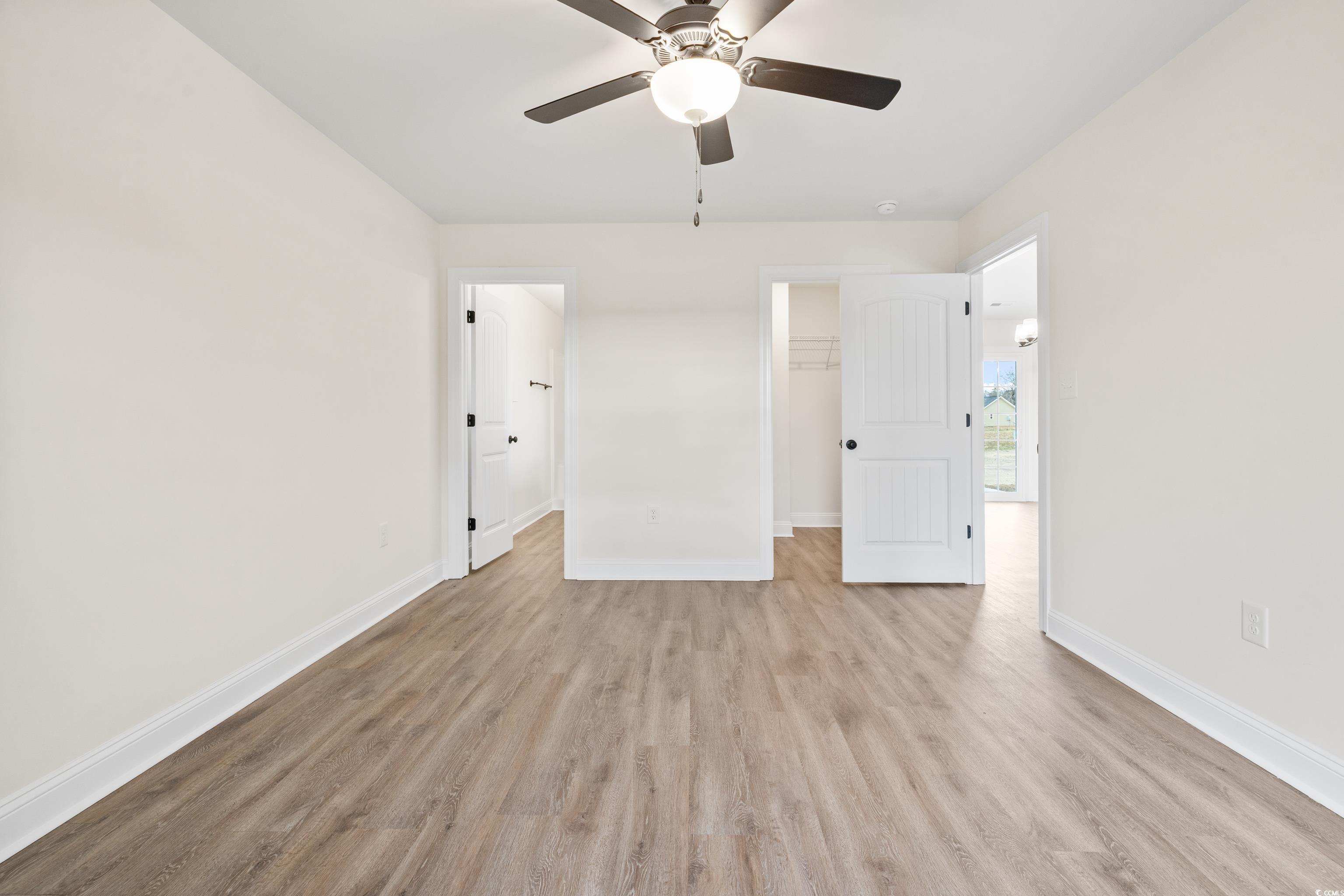 3640 Bethel Chapel Road Loris, SC 29569 - Photo 24 of 35 Unfurnished bedroom with a walk in closet, light wood-style flooring, and a ceiling fan