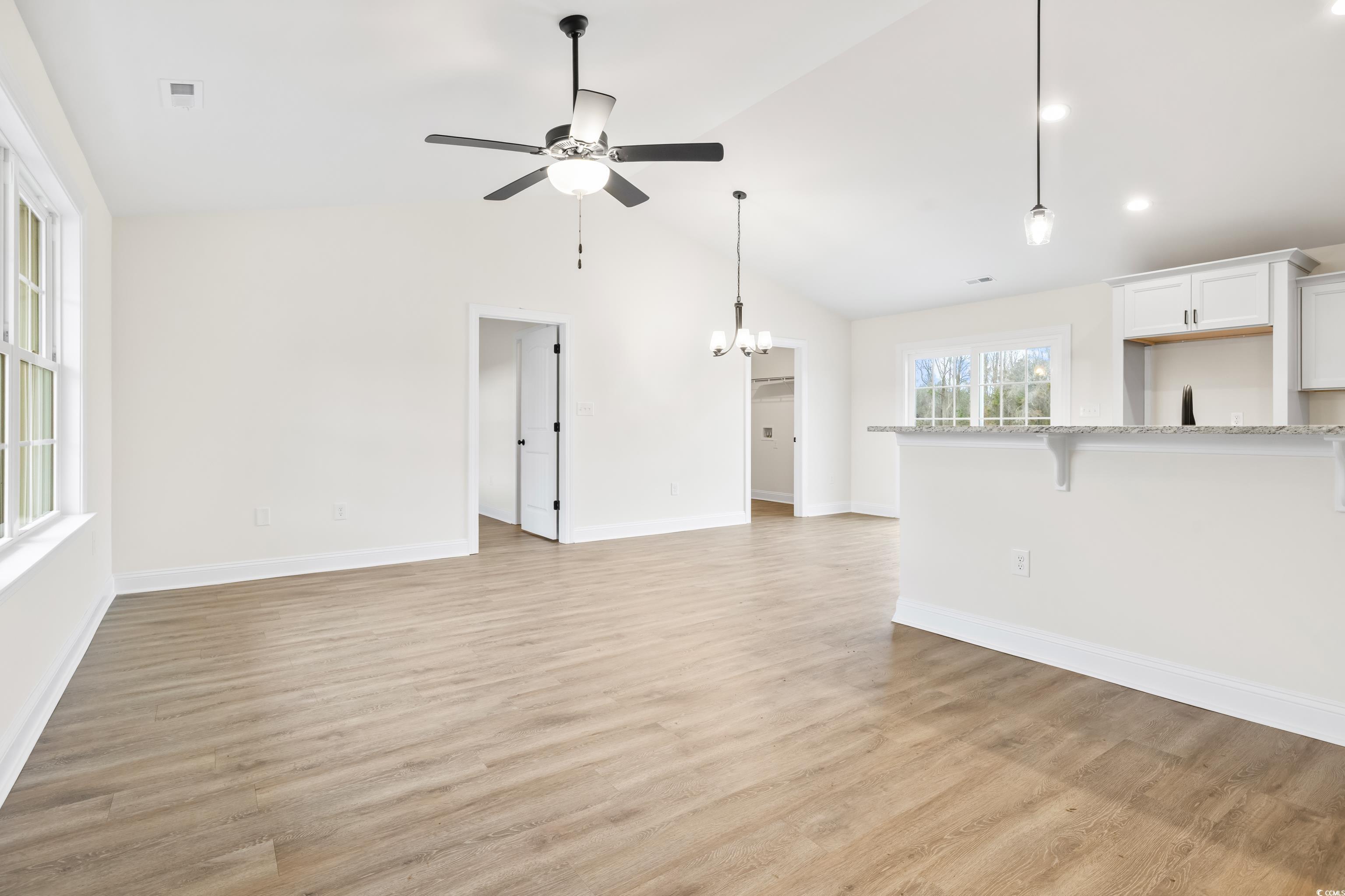 3640 Bethel Chapel Road Loris, SC 29569 - Photo 5 of 35 Unfurnished living room featuring a chandelier, light wood-style floors, ceiling fan, and high vaulted ceiling