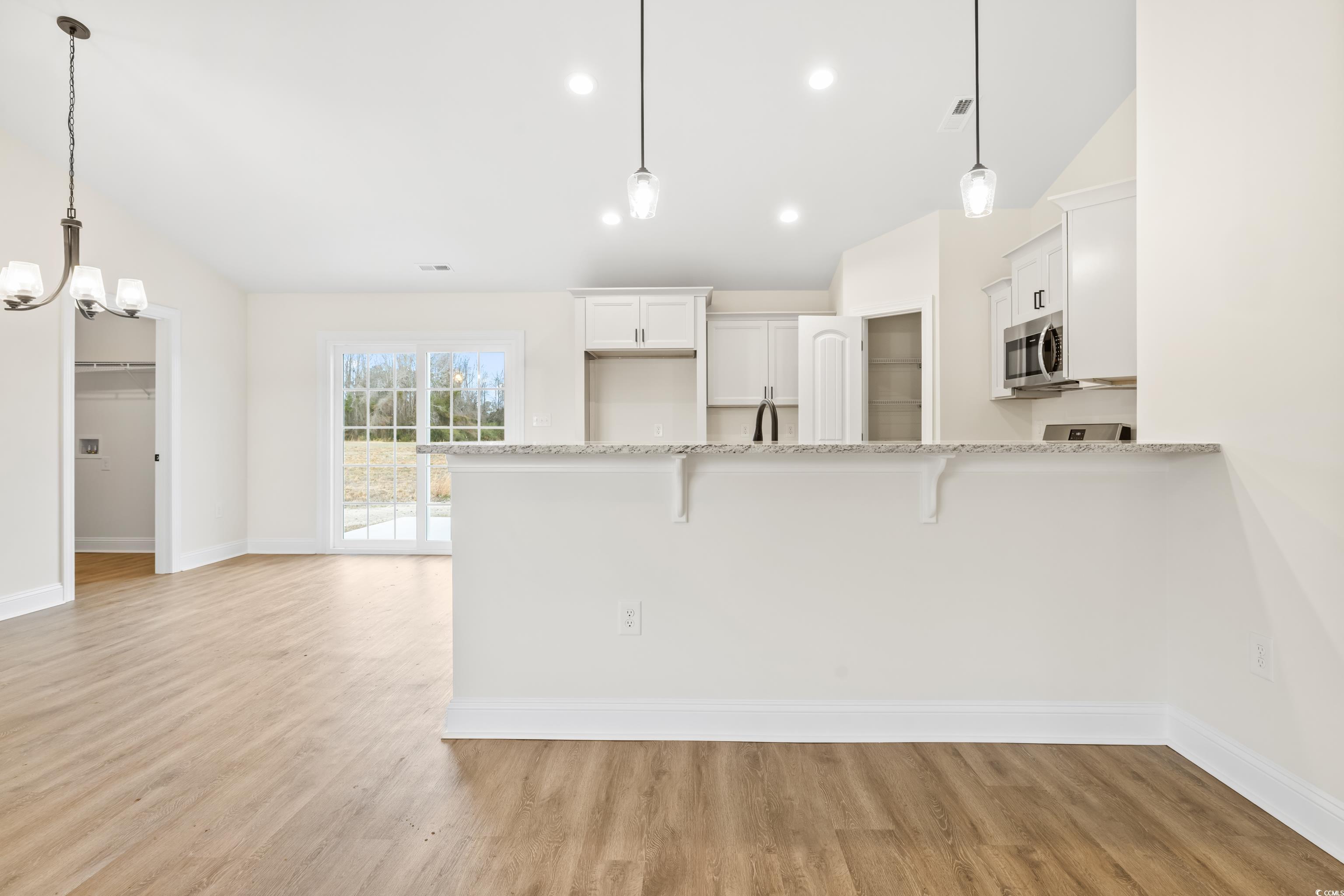 3640 Bethel Chapel Road Loris, SC 29569 - Photo 7 of 35 Kitchen featuring a breakfast bar area, white cabinetry, pendant lighting, a peninsula, and vaulted ceiling