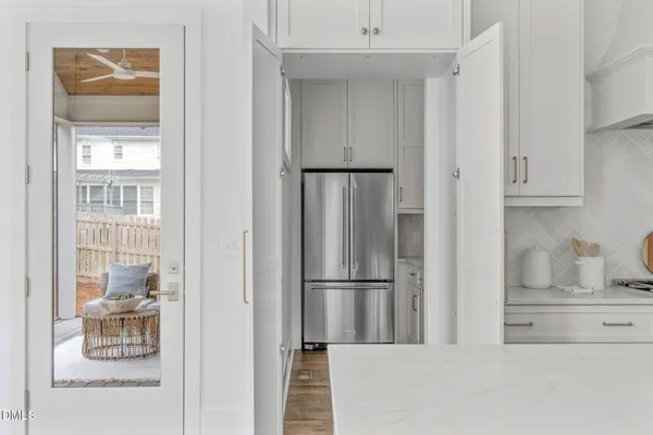 a kitchen with white cabinets and appliances