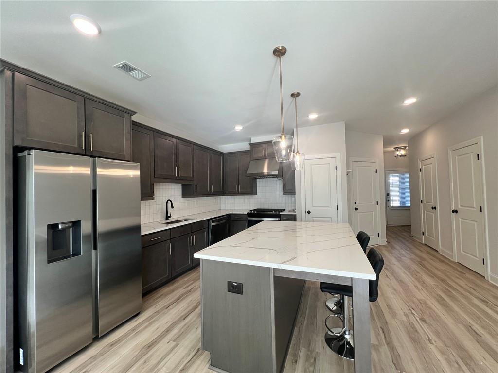 1337 Parc Bench Road Atlanta, GA 30316 - Photo 13 of 35 a kitchen with stainless steel appliances a refrigerator a sink dishwasher a stove and white cabinets with wooden floor