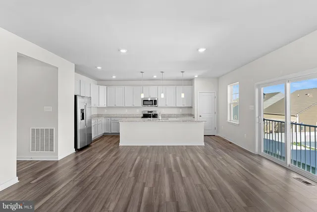 a kitchen with kitchen island white cabinets and stainless steel appliances