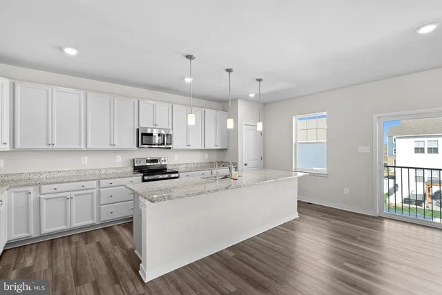 a large kitchen with kitchen island granite countertop a large counter space a sink stainless steel appliances and cabinets