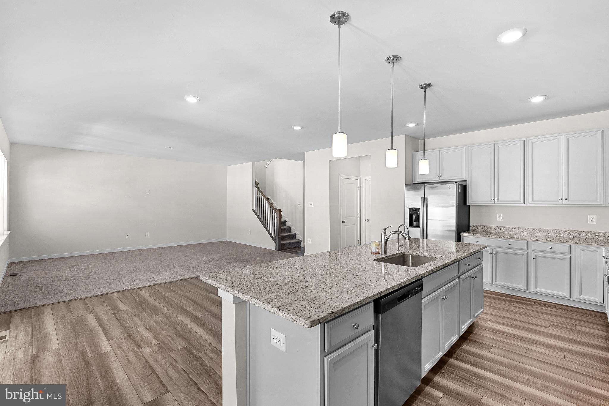 261 Short Br Drive Ranson, WV 25438 - Photo 25 of 71 a kitchen with stainless steel appliances granite countertop a sink a oven a kitchen island with wooden floor and cabinets