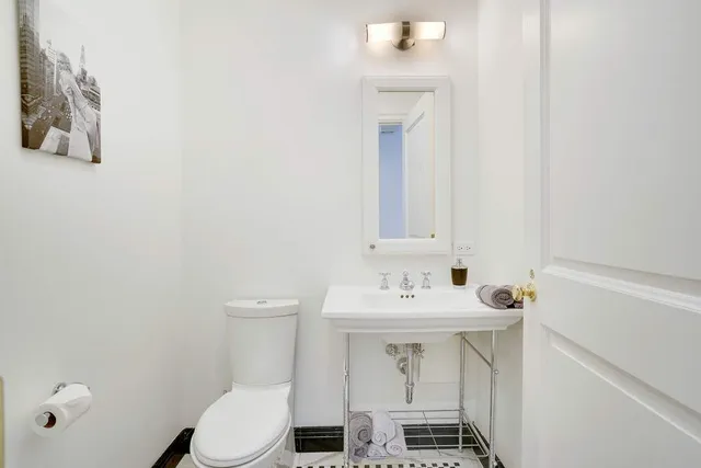 a bathroom with a sink a toilet and a mirror