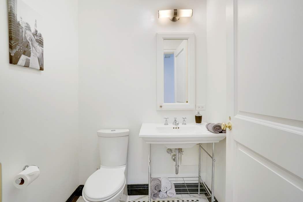515 Park Avenue, Unit 5A Manhattan, NY 10022 - Photo 14 of 19 a bathroom with a sink a toilet and a mirror