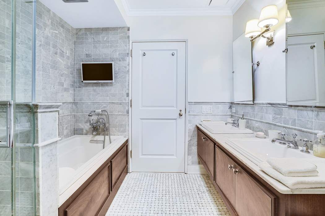 515 Park Avenue, Unit 5A Manhattan, NY 10022 - Photo 15 of 19 a bathroom with a sink a mirror and a bathtub