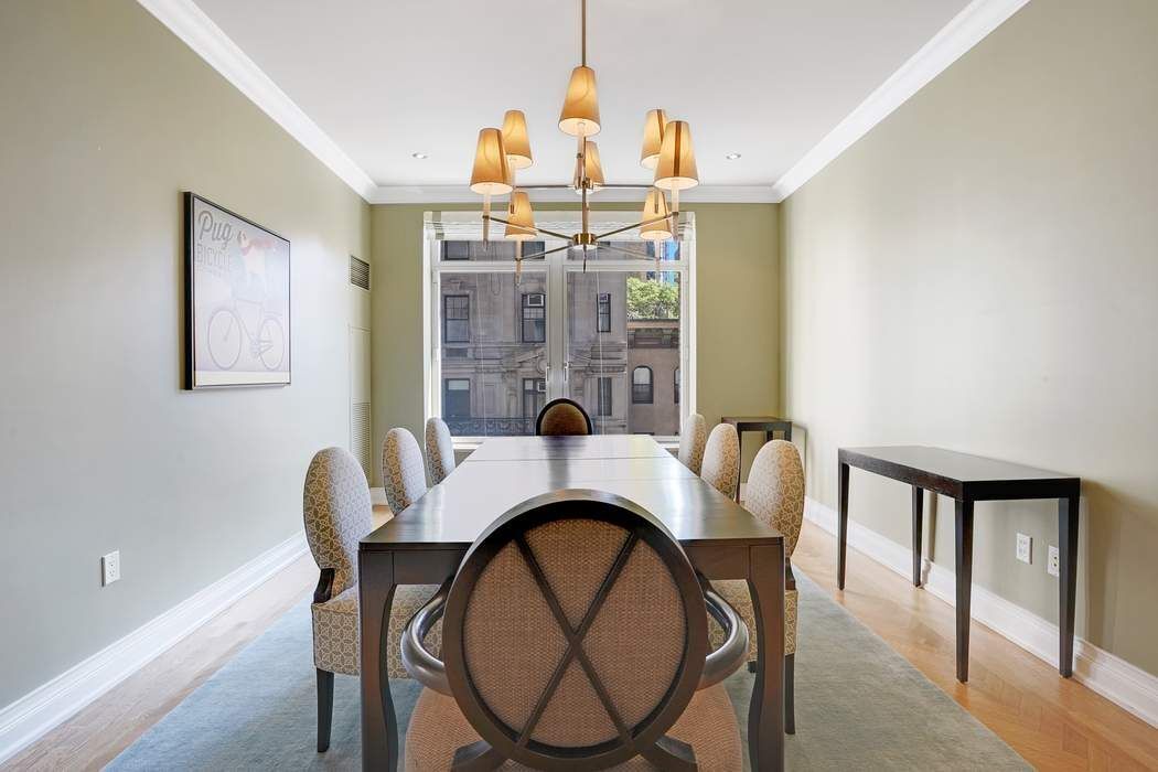 515 Park Avenue, Unit 5A Manhattan, NY 10022 - Photo 9 of 19 a dining room with furniture a chandelier and wooden floor