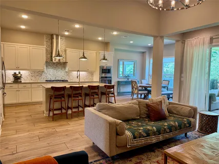 a living room with stainless steel appliances kitchen island granite countertop furniture and a view of kitchen