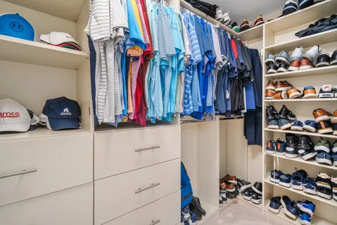 a view of walk in closet with clothes and shoes