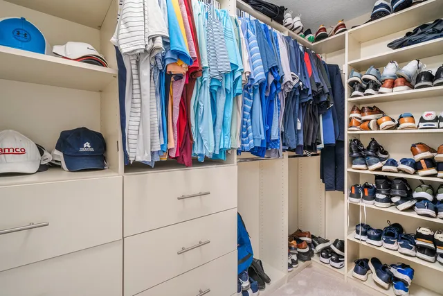 a view of walk in closet with clothes and shoes