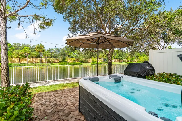 a view of a lake with a table and chairs under an umbrella