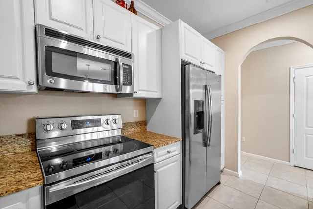 a kitchen with stainless steel appliances granite countertop a stove and a microwave