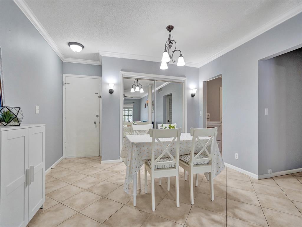 2250 Northeast 66th Street, Unit 1523 Fort Lauderdale, FL 33308 - Photo 18 of 30 a view of a dining room with furniture and chandelier