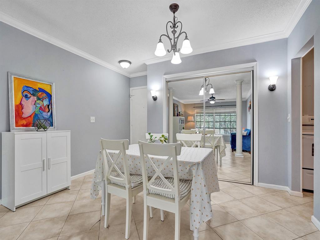 2250 Northeast 66th Street, Unit 1523 Fort Lauderdale, FL 33308 - Photo 19 of 30 a view of a dining room with furniture and chandelier
