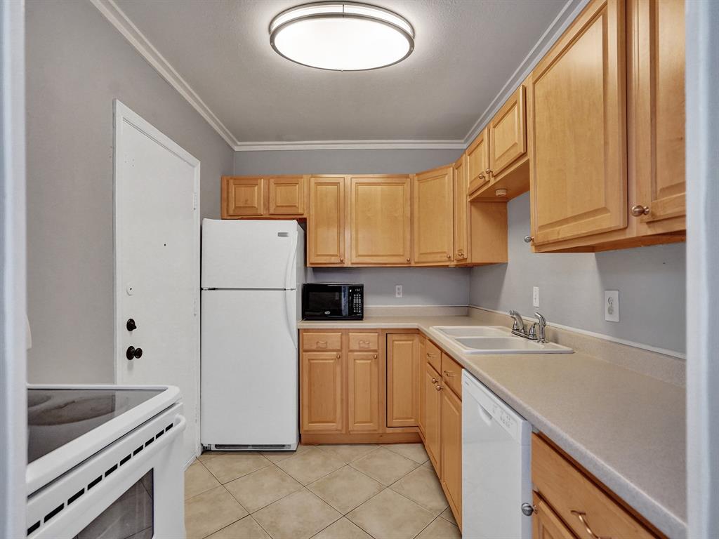 2250 Northeast 66th Street, Unit 1523 Fort Lauderdale, FL 33308 - Photo 22 of 30 a kitchen with a sink a refrigerator and cabinets