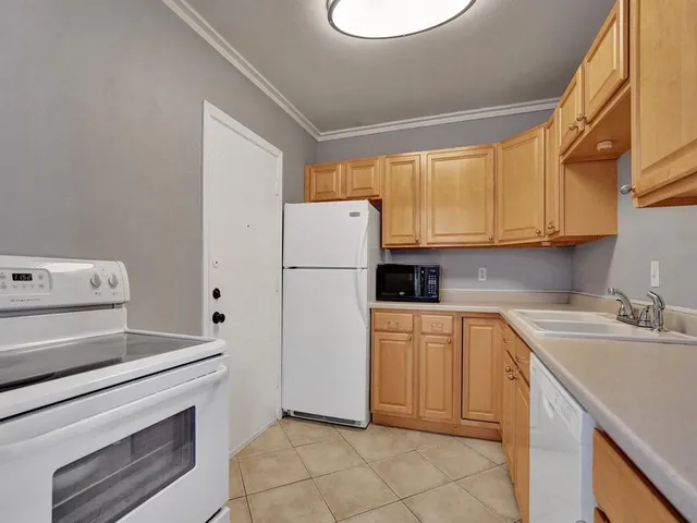 a kitchen with a refrigerator sink stove and cabinets