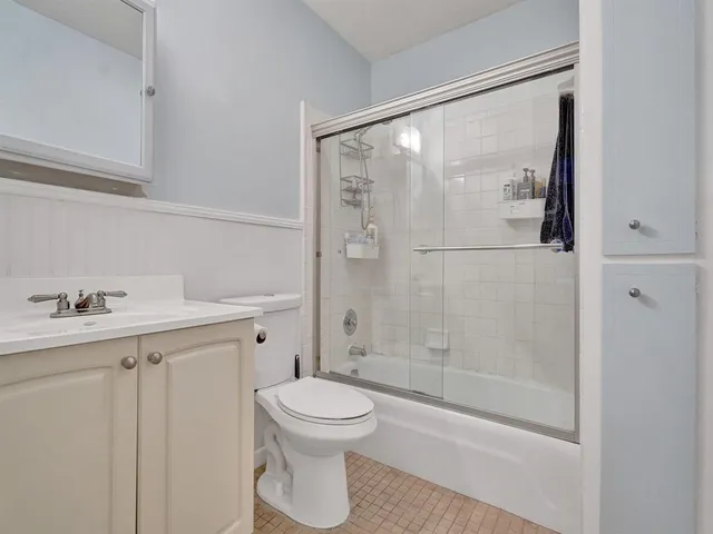 a bathroom with a shower a toilet and a sink