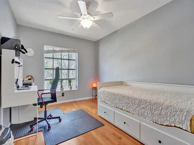 a living room with furniture hard wood floor and a ceiling fan