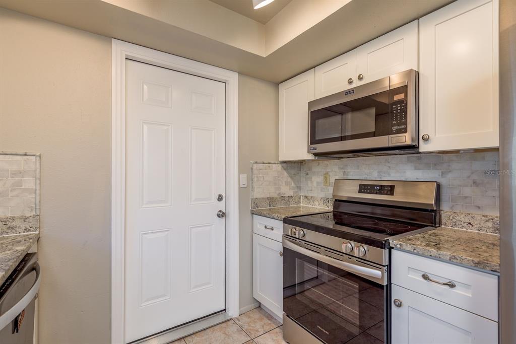 1104 Carlton Road Tarpon Springs, FL 34689 - Photo 14 of 35 a kitchen with stainless steel appliances granite countertop white cabinets and a stove top oven