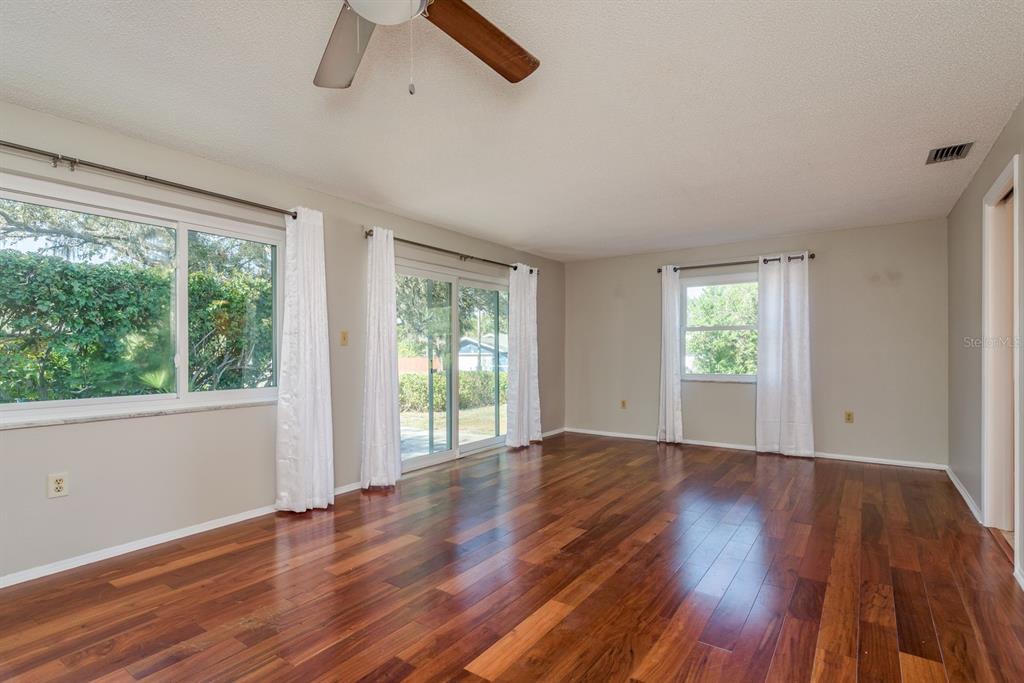 1104 Carlton Road Tarpon Springs, FL 34689 - Photo 16 of 35 a view of an empty room with wooden floor and a window